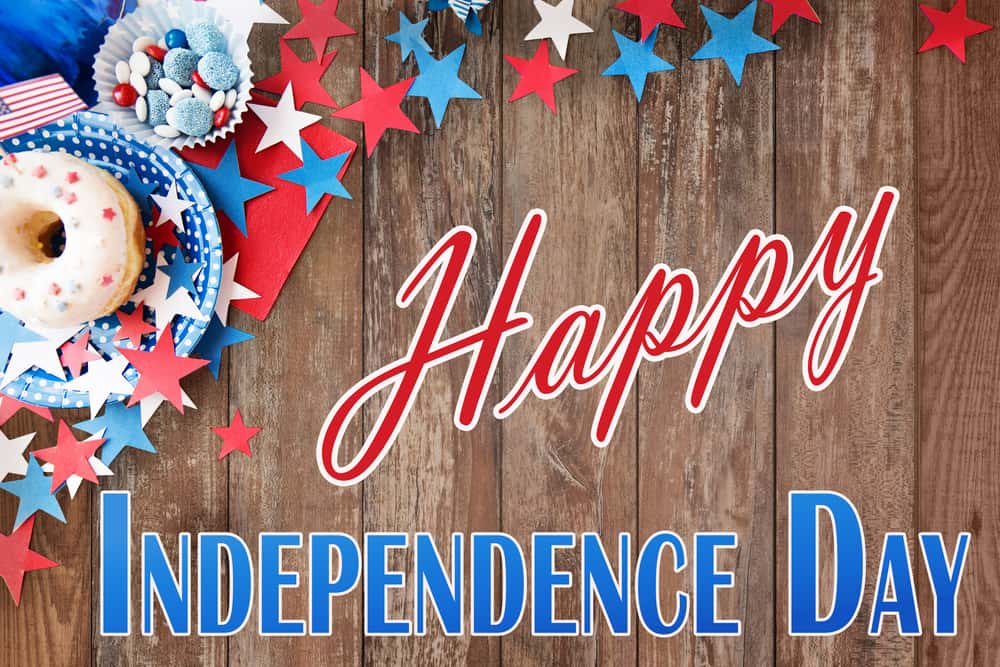 Happy independence day sign in blue and red with donuts and berries in the background