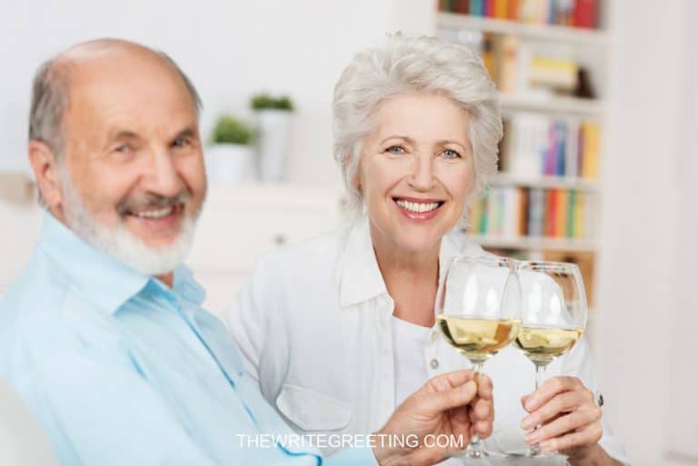 Happy senior couple CELEBRATING ANNIVERSARY WITH white wine