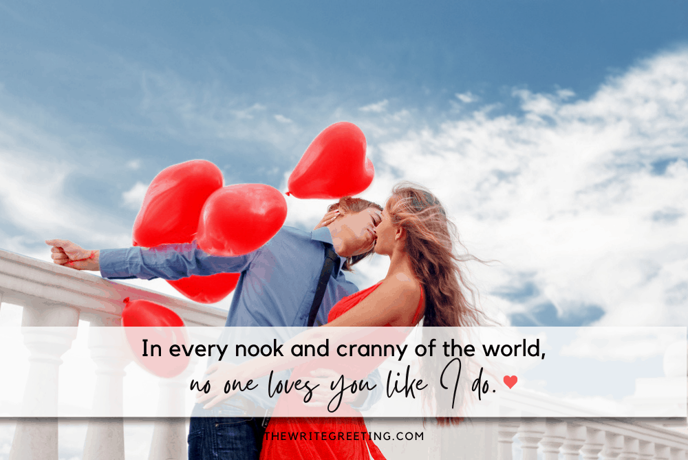 Engaged couple holding red balloons outdoors