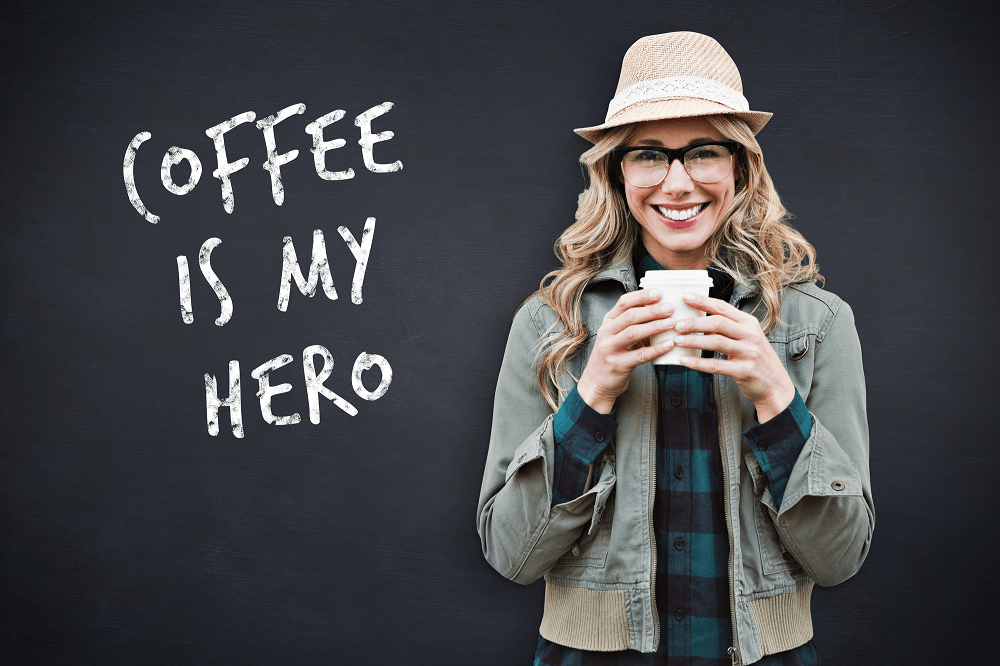 woman drinking coffee with coffee is my hero text on blackboard