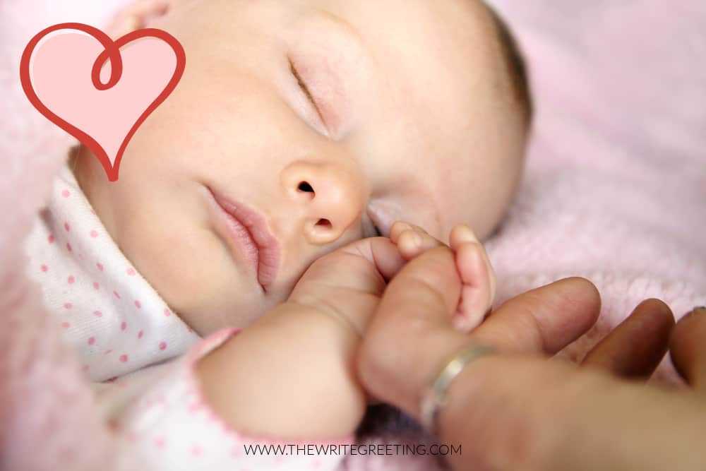 Newborn baby girl holding moms finger