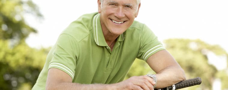 Older man in light green jumper leaning on bike