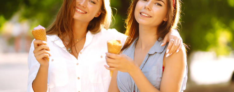 Two teenager friends female eating ice cream