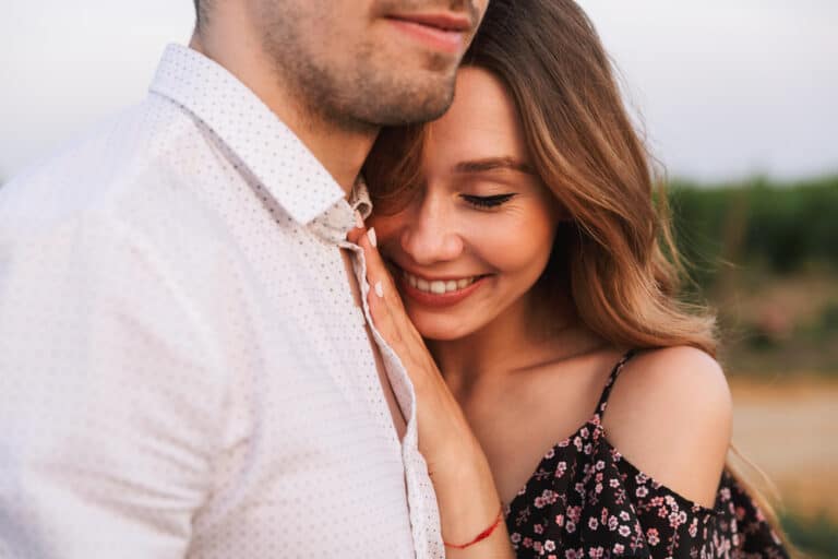Girlfriend leaning on boyfriends chest smiling