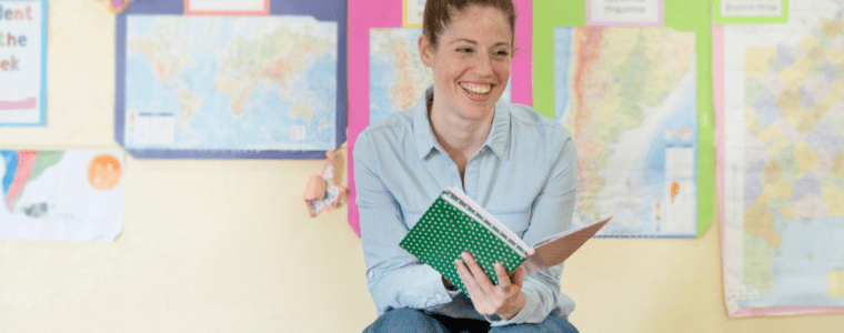 Female teacher sitting on desk teaching