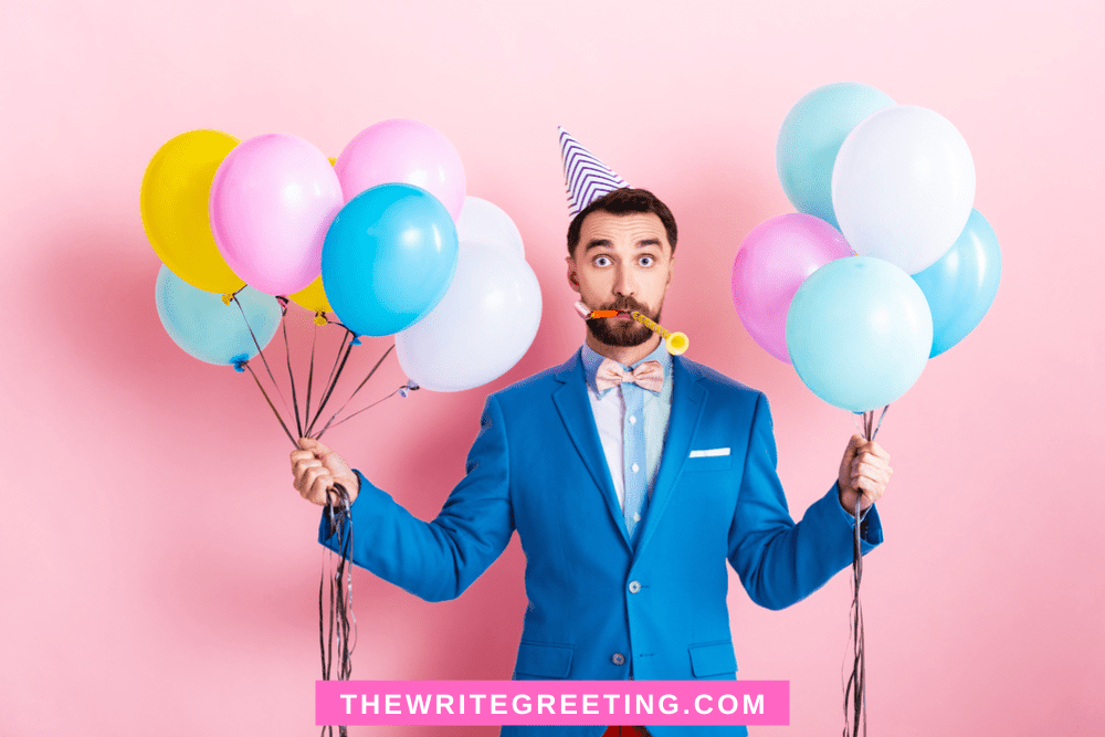 Man in blue suit holding blue, pink, white balloons