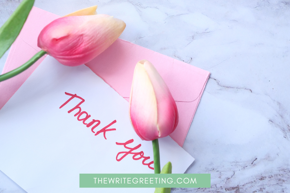 Pink flower laying by thank you card pink envelope
