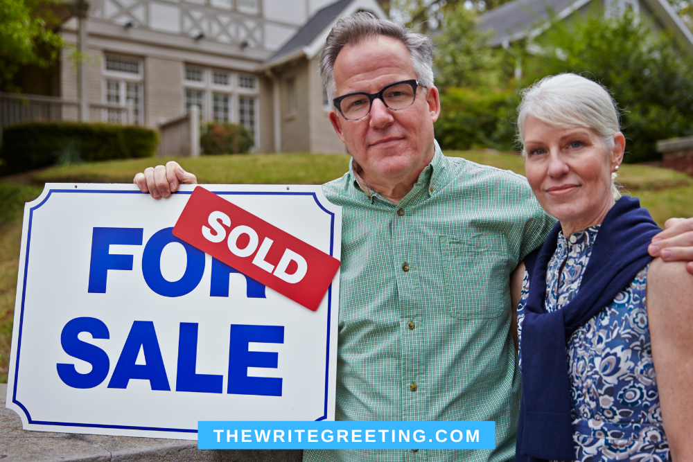 Older couple standing by sold house sign