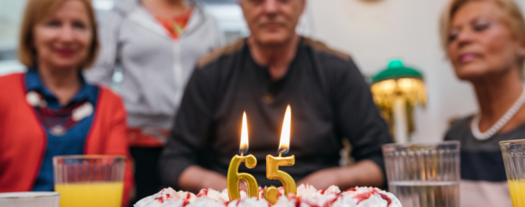 A 65 year old man celebrating his birthday with cake