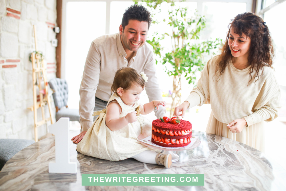 Baby girl in neutral color celebrating first birthday with red cake