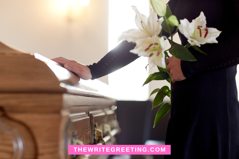 Someone putting hand on casket with white flowers
