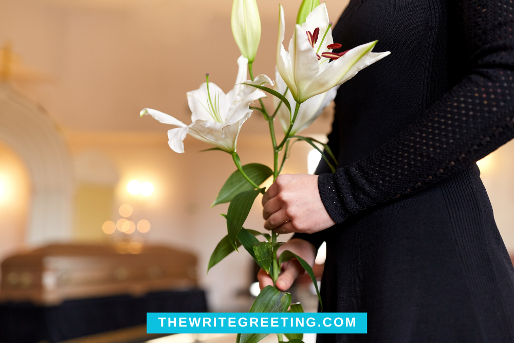 Person holding white lilly flowers at funeral