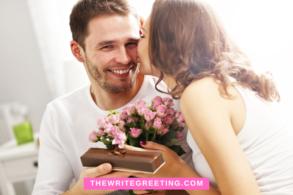 A girlfriend kissing boyfriend on cheek holding pink flowers