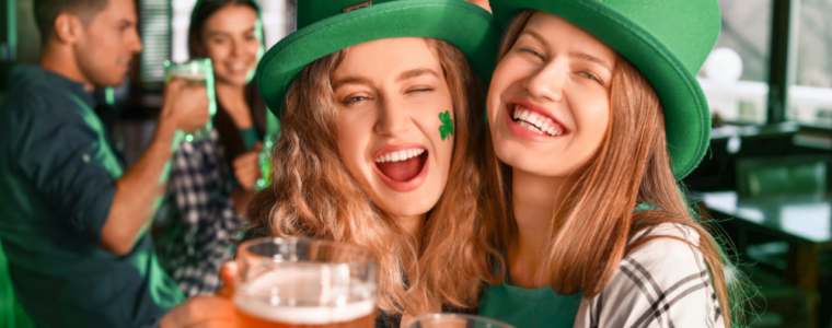 2 girls dressed in Irish gear drinking beer